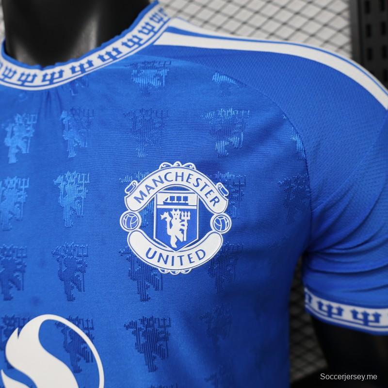 قميص اللاعب نسخة 26/27 باللون الأزرق الخاص بنادي مانشستر يونايتد مع نقشة جاكار على شكل شيطان تغطي كامل القميص