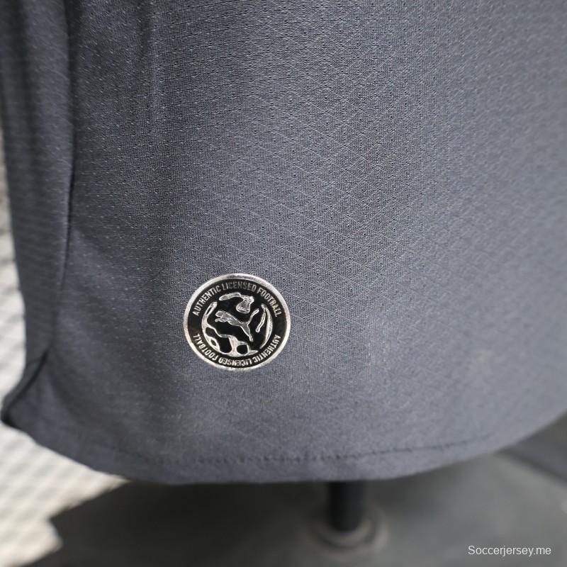 قميص اللاعب نسخة 26/27 لميلان (الزي الخارجي) باللون الأزرق الداكن مع لمسات باللون البرتقالي النحاسي