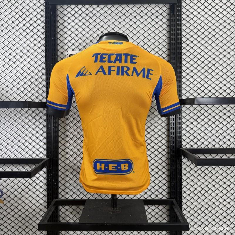 قميص اللاعب نسخة 25/26 لفريق تيغريس UANL باللون الذهبي مع شريط أزرق على الصدر، وشعار الذكرى الخامسة والستين، وقميص Sportiumbet